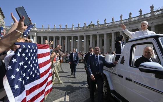 Pope Leo XIV waves to pilgrims holding a flag of the United States as he arrives in St. Peter's Square on the popemobile for his general audience at the Vatican June 18, 2025. (CNS/Vatican Media)