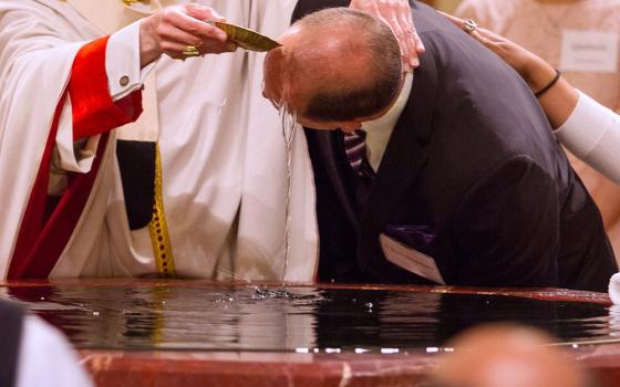 A file photo shows a catechumen being baptized during the Easter Vigil. (OSV News/Texas Catholic Herald/James Ramos)