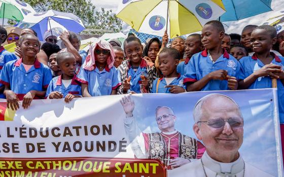 Catholic school students hold a banner as the faithful gather at Yaoundé Nsimalen International Airport in Yaoundé, Cameroon, April 15, 2026, before Pope Leo XIV's arrival to begin his apostolic journey to the African country. (OSV News/Reuters/Luc Gnago)