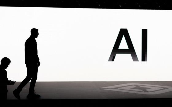 A screen reads "AI" as attendees gather at Rivian's first Autonomy and AI Day in Palo Alto, California, Dec. 11 2025, showing developments in self-driving technology. (OSV News/Reuters/Carlos Barria)
