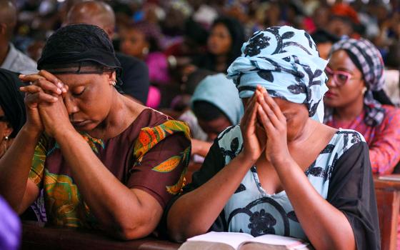 A woman is pictured in a file photo praying during Mass at Holy Rosary Catholic Church in Abuja, Nigeria. A new report from Pew Research Center shows that social hostilities related to religion rose sharply in several countries during 2023. (OSV News/Reuters/Afolabi Sotunde)