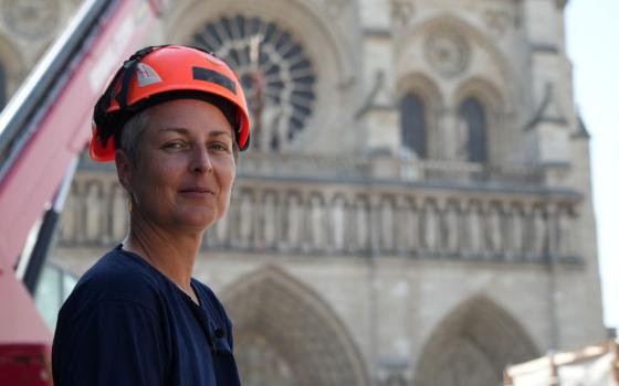 Camille Colonna, archaeologist in charge of operations, wearing a safety helmet, poses in front of Notre Dame Cathedral during excavations in Paris June 1, 2026. (AP/Nicolas Garriga)