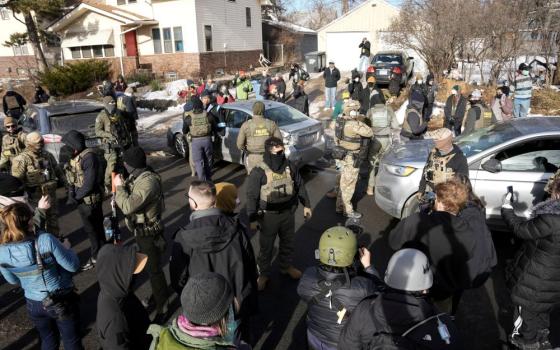 Federal agents stand by a damaged civilian's car hit by U.S. Immigration and Customs Enforcement agents in Minneapolis Jan.12, 2026. (OSV News/Reuters/Tim Evans)