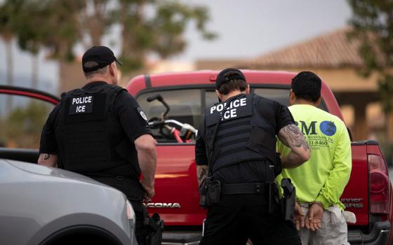 U.S. Immigration and Customs Enforcement officers detain a man during an operation in Escondido, Calif. (RNS/AP/Gregory Bull)