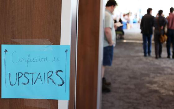 A sign in the convention center at the La Crosse convention center in Wisconsin points attendees at the  "Zeale for America 250 Rally" to a space upstairs where the sacrament of confession is available. (Martyn Smith)