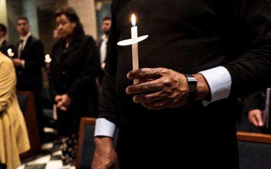 People at the Cathedral of the Most Blessed Sacrament in Detroit hold candles April 16, 2022, during the start of the Easter Vigil with then Detroit Archbishop Allen Vigneron as presider. (CNS/Detroit Catholic/Rosa Maria Zamarron)