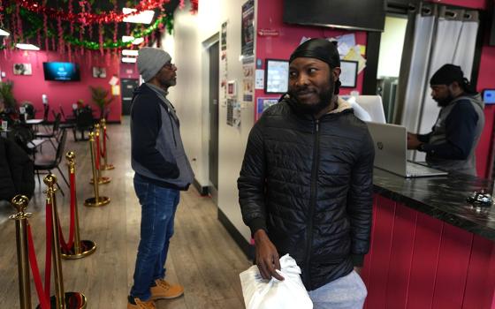 Roudechel Charpentier, a Haitian migrant who lives and works legally in the U.S. under Temporary Protected Status, walks out of the Rose Goute Creole restaurant, Feb. 3, 2026, in Springfield, Ohio. (AP photo/Luis Henao)