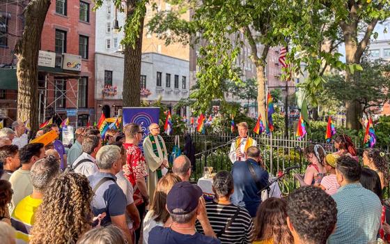 Worshippers pray at a Pride Mass organized by Out at St. Paul's, the LGBTQ+ ministry of St. Paul the Apostle in Manhattan, at the Stonewall National Monument in Christopher Park in New York, steps away from the Stonewall Inn, June 25, 2026. (NCR photo/Camillo Barone)