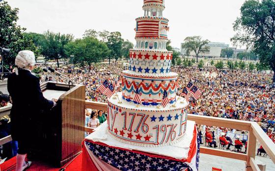 A man dressed in a period costume including powdered wig speaks to crowds while a giant cake sits beside him in Washington, D.C., July 4, 1976, during celebrations for the nation's bicentennial. (AP)