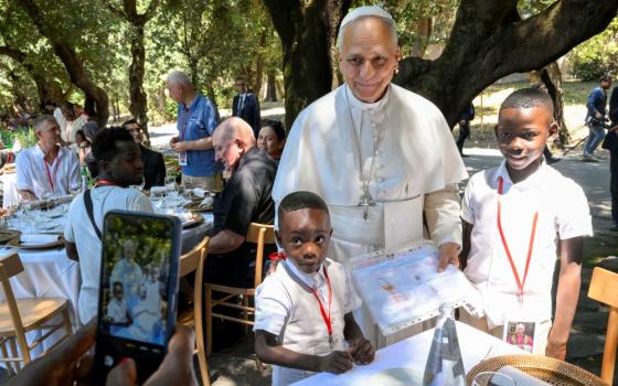 Pope Leo XIV poses for a photo with two young boys at a lunch with vulnerable people from the Diocese of Rome at Borgo Laudato Si, in the pontifical gardens of Castel Gandolfo, Italy, July 11, 2026. (OSV News/Vatican Media/Simone Risoluti)