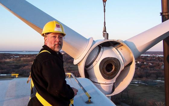 Benedictine Br. Joseph Byron, monk at Portsmouth Abbey and boarding school in Portsmouth, Rhode Island, stands on top of the abbey's wind turbine in March 2006. (Courtesy of Joseph Byorn)