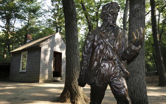 In this file photo, a statue of Henry David Thoreau stands outside a replica of his cabin near the shores of Walden Pond in Concord, Massachusetts. (AP Photo/Michael Dwyer, File)